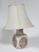 A 1970s style pottery cream glazed octagonal panel sided lamp with Rune style circular impressed