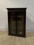 A George III mahogany wall hanging corner cabinet, with dentil cornice over arcaded frieze, two