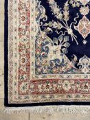A wool pile ground rug, the blue field with ivory medallion and border 263cm x 156cm