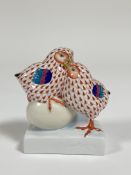 A Herend porcelain pair of Chicks with an egg in a orange pattern with gilt beaks and claws. ( h