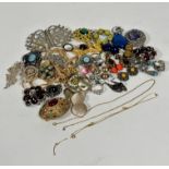 A collection of costume jewellery including an amethyst coloured paste set oval brooch, an