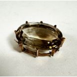 A yellow metal mounted oval pale citrine brooch in claw setting, (3.5cm x 2.5cm)