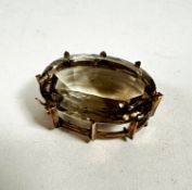 A yellow metal mounted oval pale citrine brooch in claw setting, (3.5cm x 2.5cm)