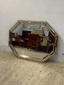 A floral embossed gilt brass and sectional glass framed wall hanging mirror of octagonal outline,