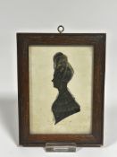 A Regency style silhouette portrait miniature highlighted with gilt to lace and hair, in oak