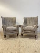 A pair of Harris Tweed barrel back armchairs, upholstered in grey wool with leather piping, raised