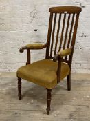 A Victorian mahogany open armchair, the rail back over upholstered seat and arm rests with