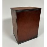 A mahogany cabinet, the rectangular top with reeded edge, above a hinged panel door enclosing a