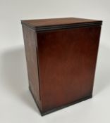 A mahogany cabinet, the rectangular top with reeded edge, above a hinged panel door enclosing a