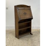 A 1930's/40s oak bureau, the fall front revealing fitted interior over two open shelves on panel end