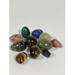 A collection of polished egg shaped hardstone including two tigers eye eggs, a circular tigers eye