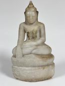 A carved alabaster seated figure of Buddha seated on lotus leaf moulded and carved base, traces of