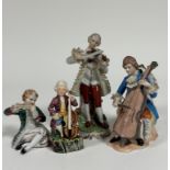 A group of four Continental porcelain figurers each playing various instruments such as violin,