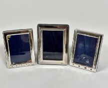 A pair of silver rectangular cushion framed photograph frames, the lined interiors of blue plush,