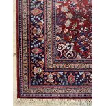 A Persian Kashan rug, the busy red field within a multi line border, moth damage 335cm x 233cm