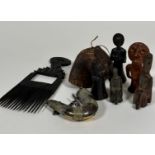 An African treen carved comb, a treen carved oval bell, a brass and steel powder horn with hinged