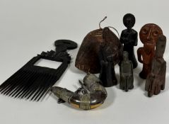 An African treen carved comb, a treen carved oval bell, a brass and steel powder horn with hinged