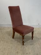 A late Victorian high back upholstered chair, raised on turned front supports, H91cm