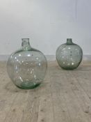 A matched pair of green glass demijohns, H55cm