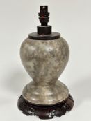 A grey mottled alabaster baluster vase base with hardwood top, raised on Chinese hardwood associated