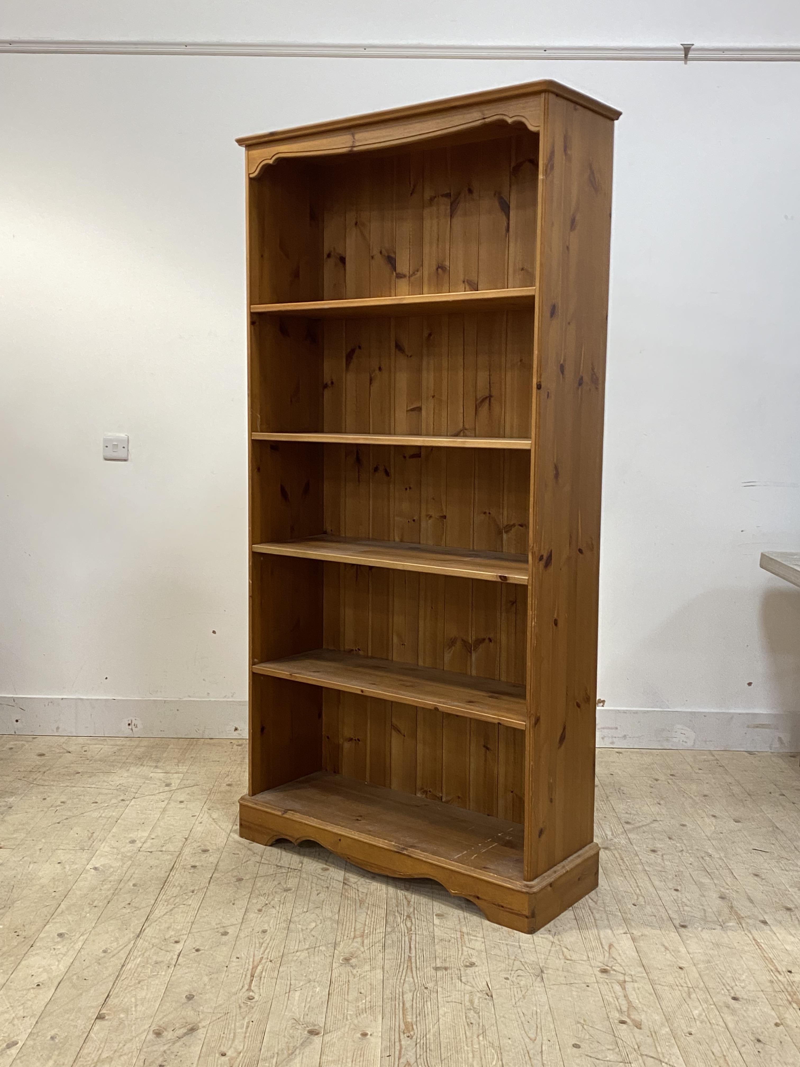 A polished pine floor standing bookcase fitted with four adjustable shelves, H191cm, W96cm, D35cm