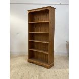 A polished pine floor standing bookcase fitted with four adjustable shelves, H191cm, W96cm, D35cm