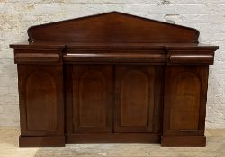 A mid 19th century mahogany side cabinet, with arched ledge back over inverted break front, three