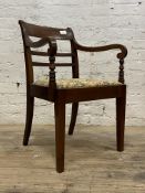 An Edwardian mahogany elbow chair, scrolled arm rests with turned uprights, drop in seat pad, raised