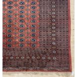 An Afghan bokhara carpet, the red field with multiple rows of guls within a guarded border 379cm x