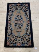 A Chinese rug, the black field with floral design, 176cm x 74cm