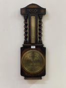 An early 20th century oak cased aneroid barometer and thermometer, the floral carved case with