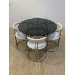 An Italian post modern dining suite, circa 1970's, the table with circular smoked plate glass top on