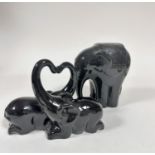 A black glazed Indian elephant standing figure (22cm x 18cm) and a pair of Crouched Elephants with
