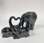 A black glazed Indian elephant standing figure (22cm x 18cm) and a pair of Crouched Elephants with