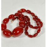 A 1920s style amber oval graduated bead necklace, missing part of clasp, (L 30cm) of carnelian