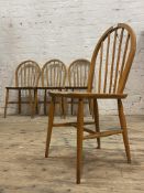 Ercol, A set of four beech and elm dining chairs, hoop and spindle backs, saddle seats, raised on