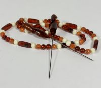 An amber, lozenge and bead alternating necklace, (39cm) with white plastic bead spacers and a pair