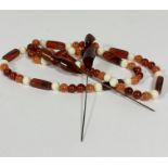 An amber, lozenge and bead alternating necklace, (39cm) with white plastic bead spacers and a pair