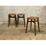 A set of three 1950's stained beech bar stools, vinyl upholstered seats raised on splayed
