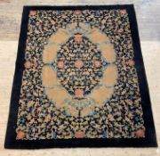 A Chinese rug, the black field with floral design, 359cm x 282cm