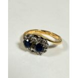 An 18ct gold two stone sapphire cross over ring, each circular cut sapphire is approximately .