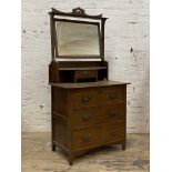 An Art Nouveau period walnut dressing chest, with swing mirror over trinket drawer and three long