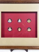 An oak box frame with set of six Japanese porcelain circular buttons depicting characters from