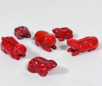 A pair of carved red coral miniature recumbent Rabbits (2cm x 5cm), three miniature red coral