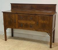 An early 20th century mahogany ledge back sideboard, the reeded top with inverted break front over
