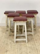 A set of six early 20th century white painted pine stools, the tops later covered in red faux