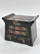 A Japanese 1920s black lacquered jewellery casket with hinged top above an arrangement of two long