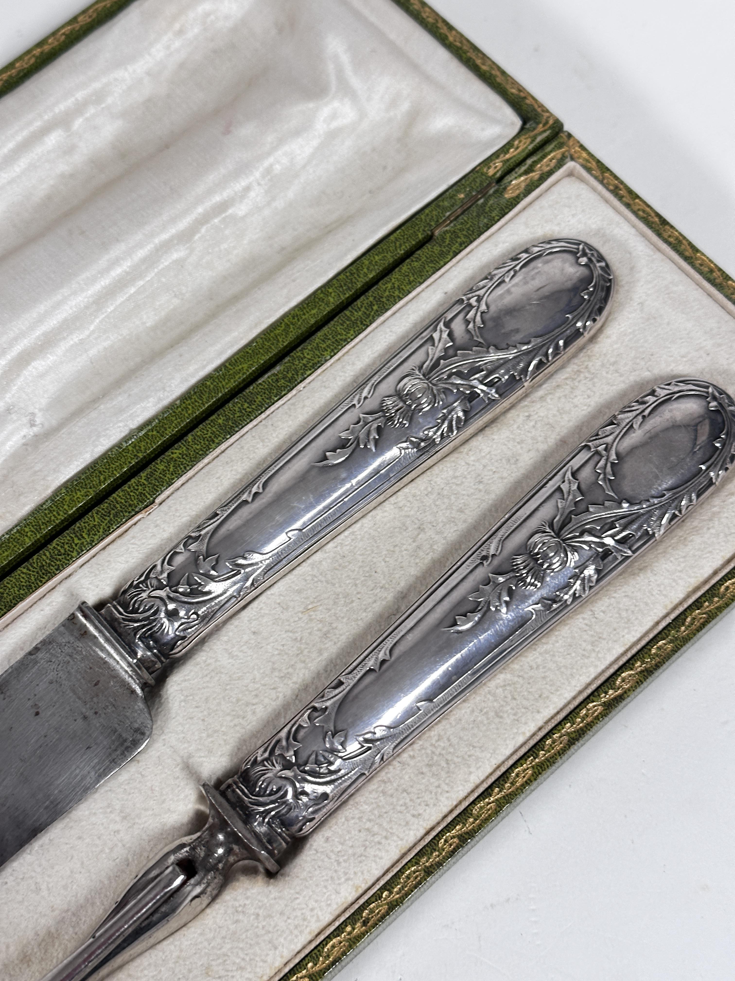 A pair of Dutch white metal thistle decorated handled carving knife and fork, in original - Image 2 of 2