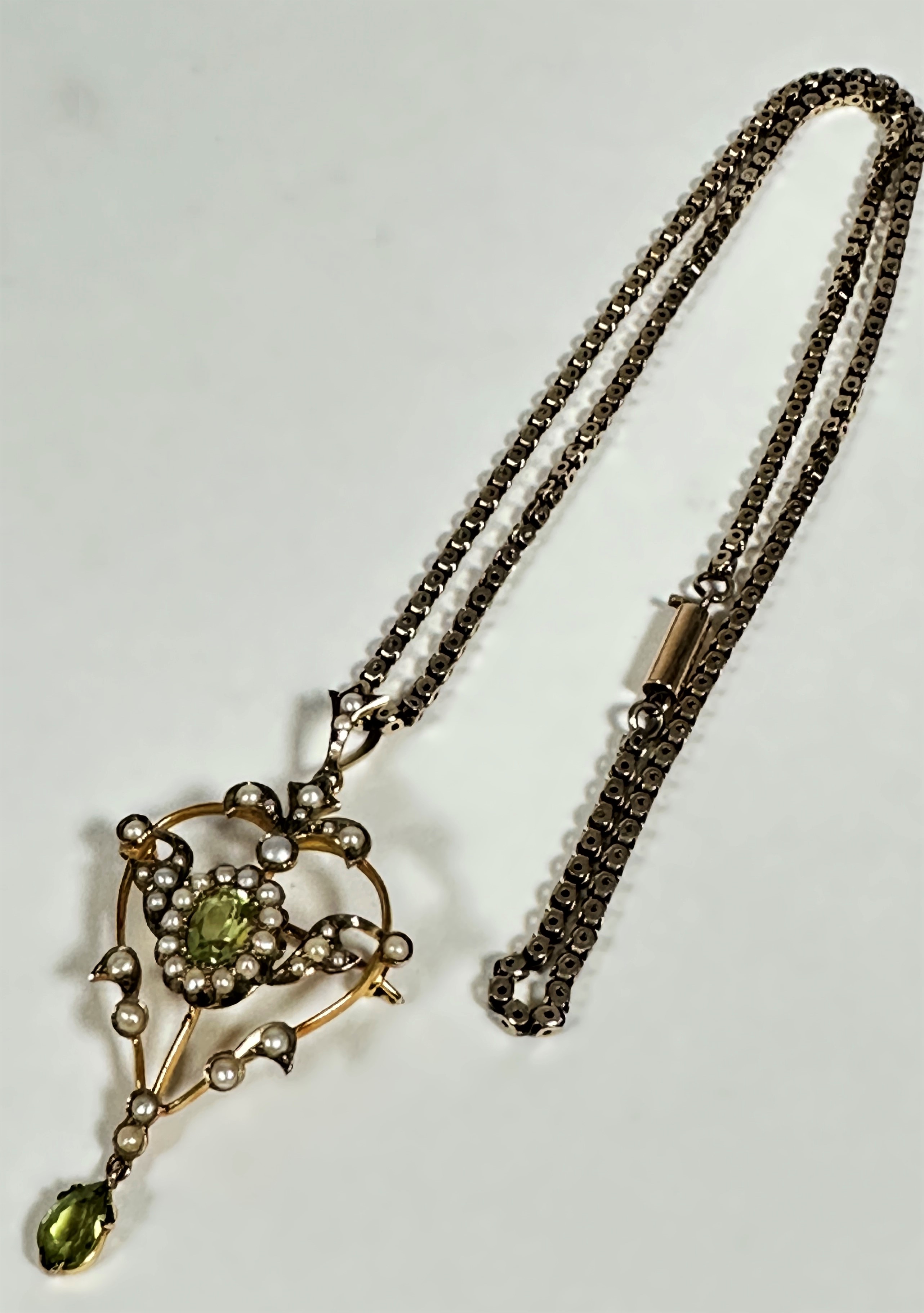 An Edwardian 9ct gold open work brooch pendant set of heart shape, set central oval peridot, set