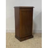 A Victorian mahogany cabinet, the panelled door enclosing pigeon holes and a drawer, raised on